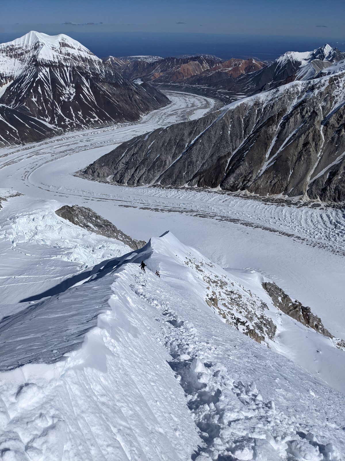 Skiers on the knife edge ridge portion of the Archangel Ridge descent