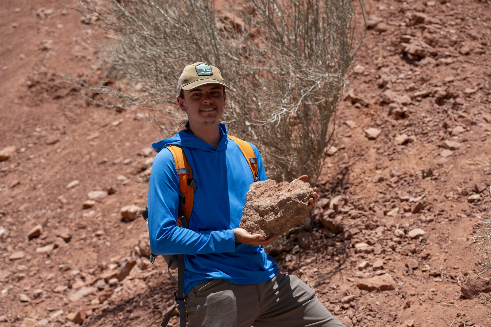 Parker Hazelbush in the field in Chile, holding a crinoid-bearing hand specimen